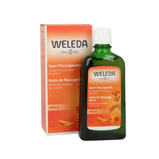 Een flesje Weleda massageolie naast het verpakkingsdoosje